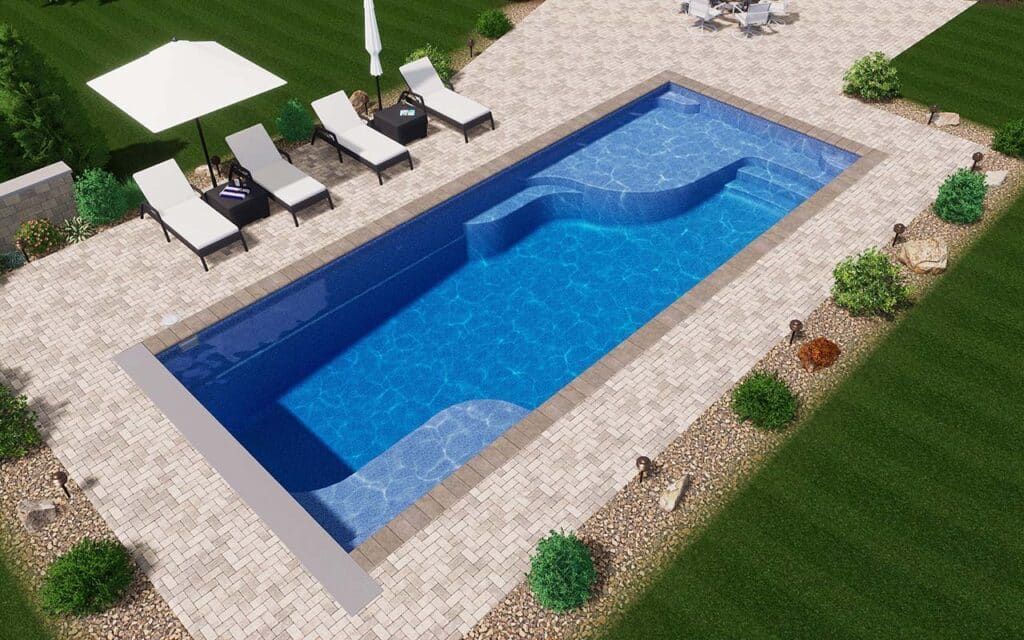 Rectangular blue pool with lounge chairs on a stone patio and desert landscaping around it