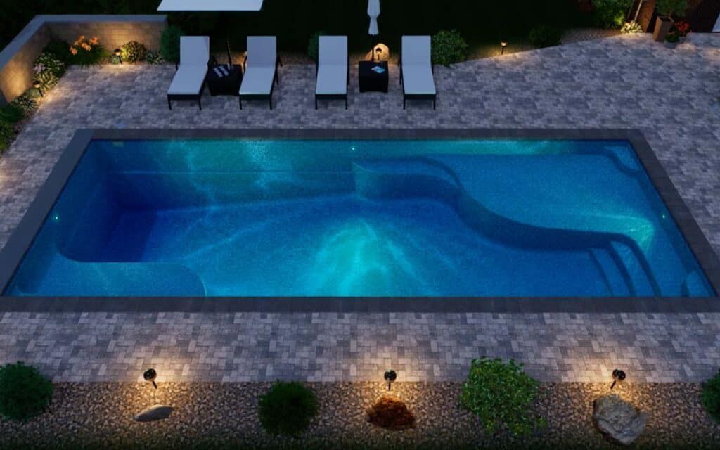 Nighttime backyard pool with blue water, lounge chairs, and garden lights lining the stone patio.