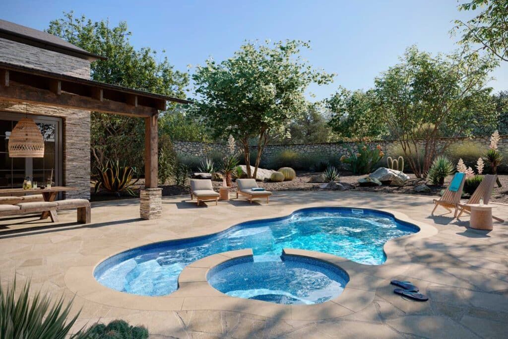 Backyard pool with shallow blue water, lounge chairs, and a shaded patio beside trees and desert landscaping