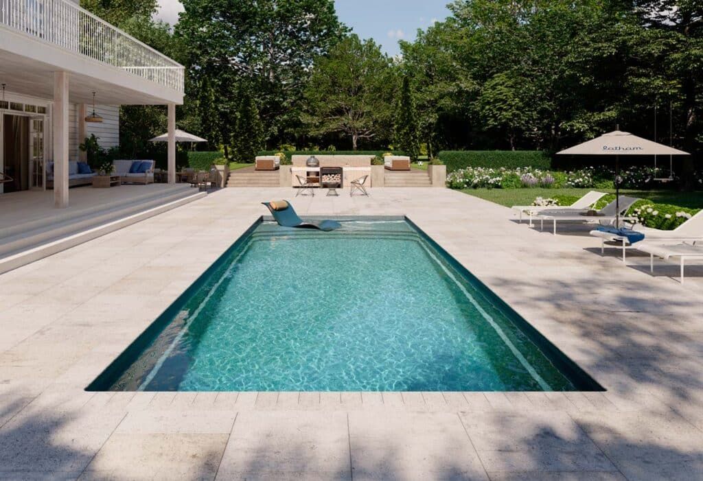 Backyard pool with turquoise water, sun loungers, shaded patio, and trees surrounding the deck