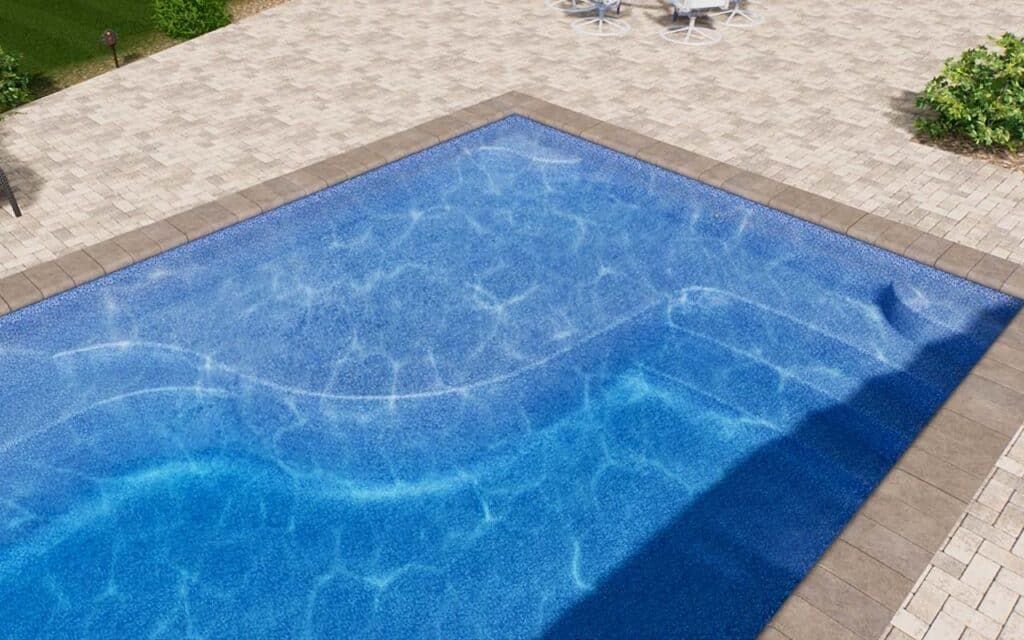 Blue swimming pool with sunlit water and a tiled deck around the edges