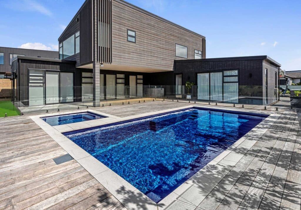Modern house patio with a blue swimming pool and wood deck
