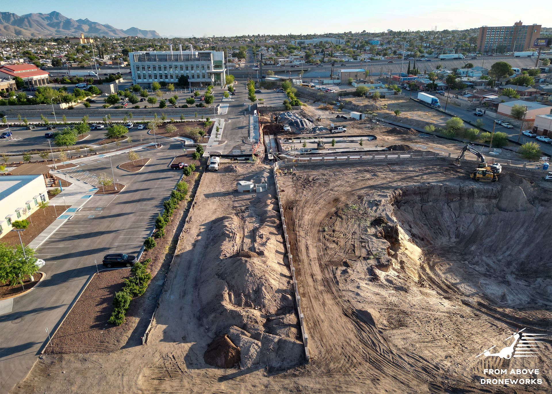 An aerial view of a construction site with a city in the background.