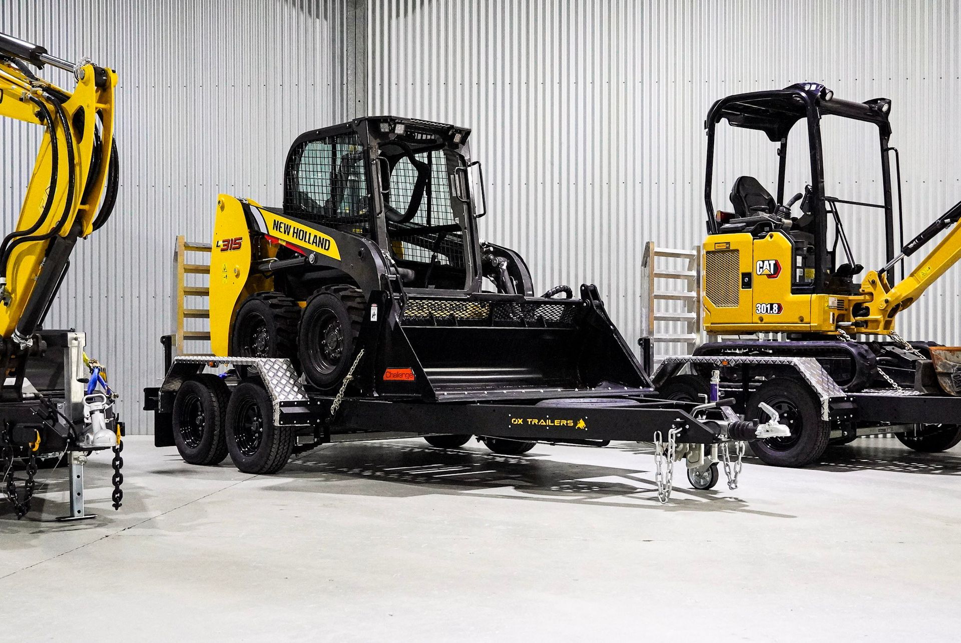 The Trade series plant trailer in a show room carrying a new holland a315 skidsteer