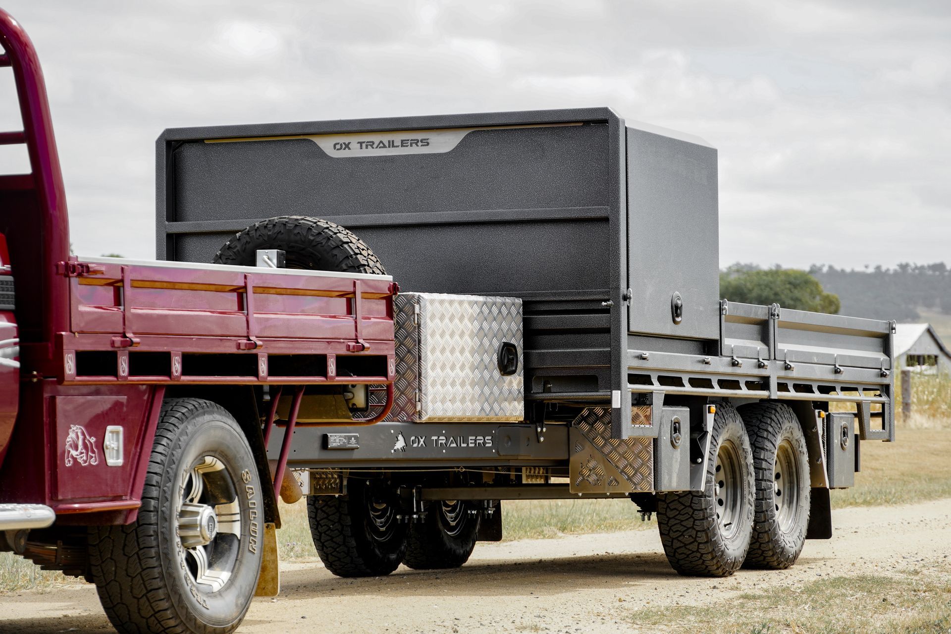 three built tough flat top trailers by a country dam.