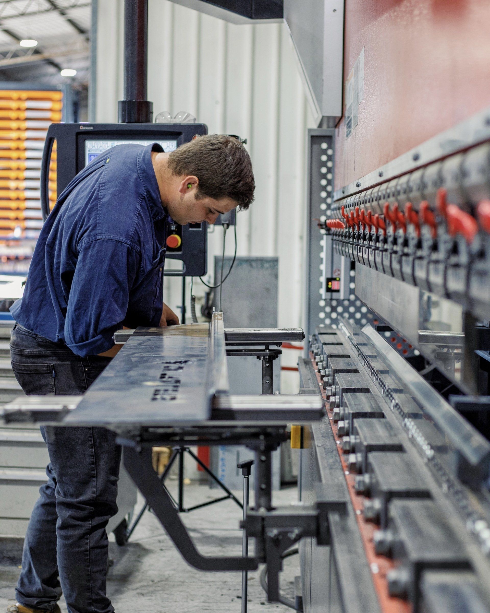 Professional team member at CNC Machine folding an Ox Trailer Chassis after Laser Cutting.