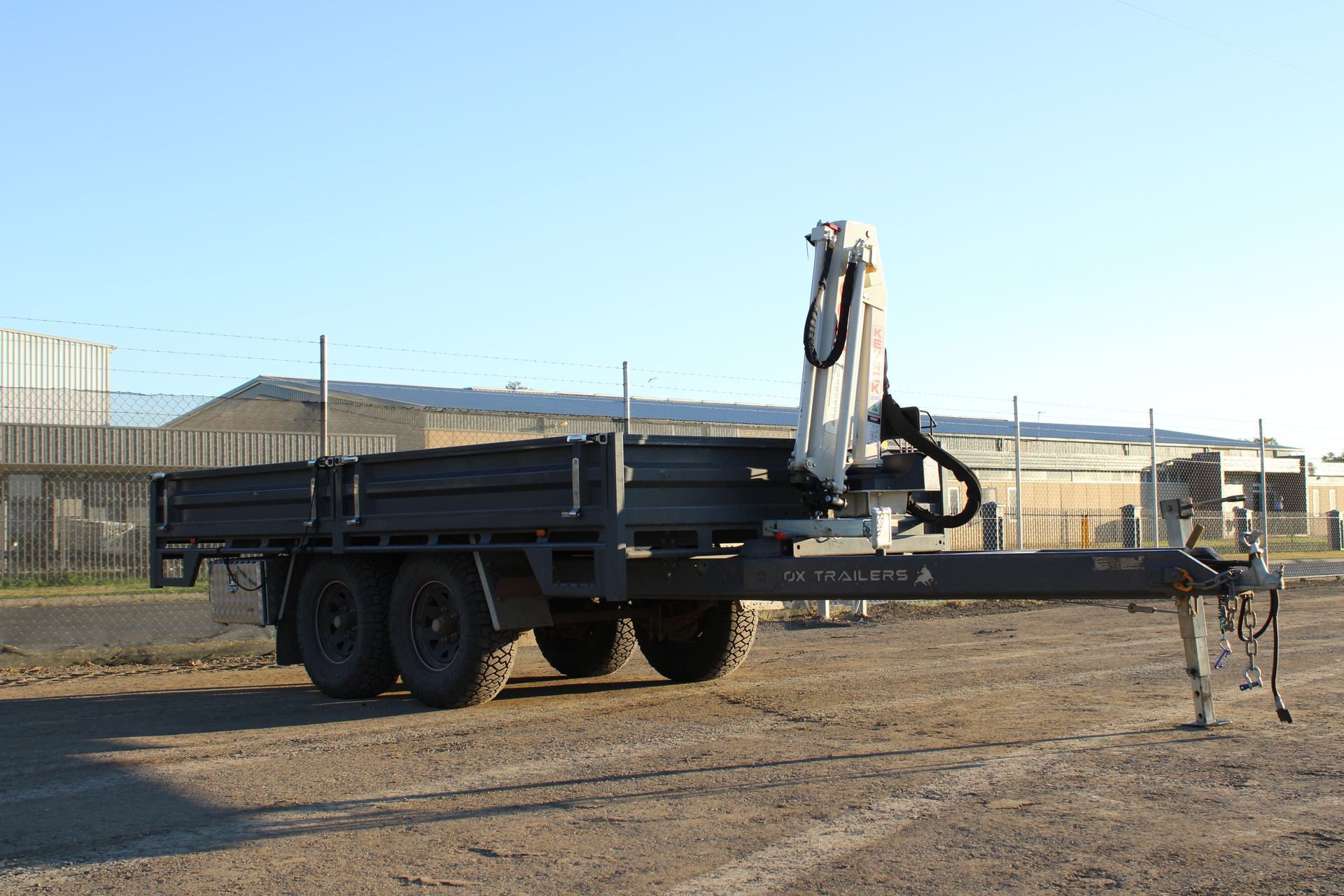 An ox trailers flat top trailer on the construction site of WestBuilt Homes. 