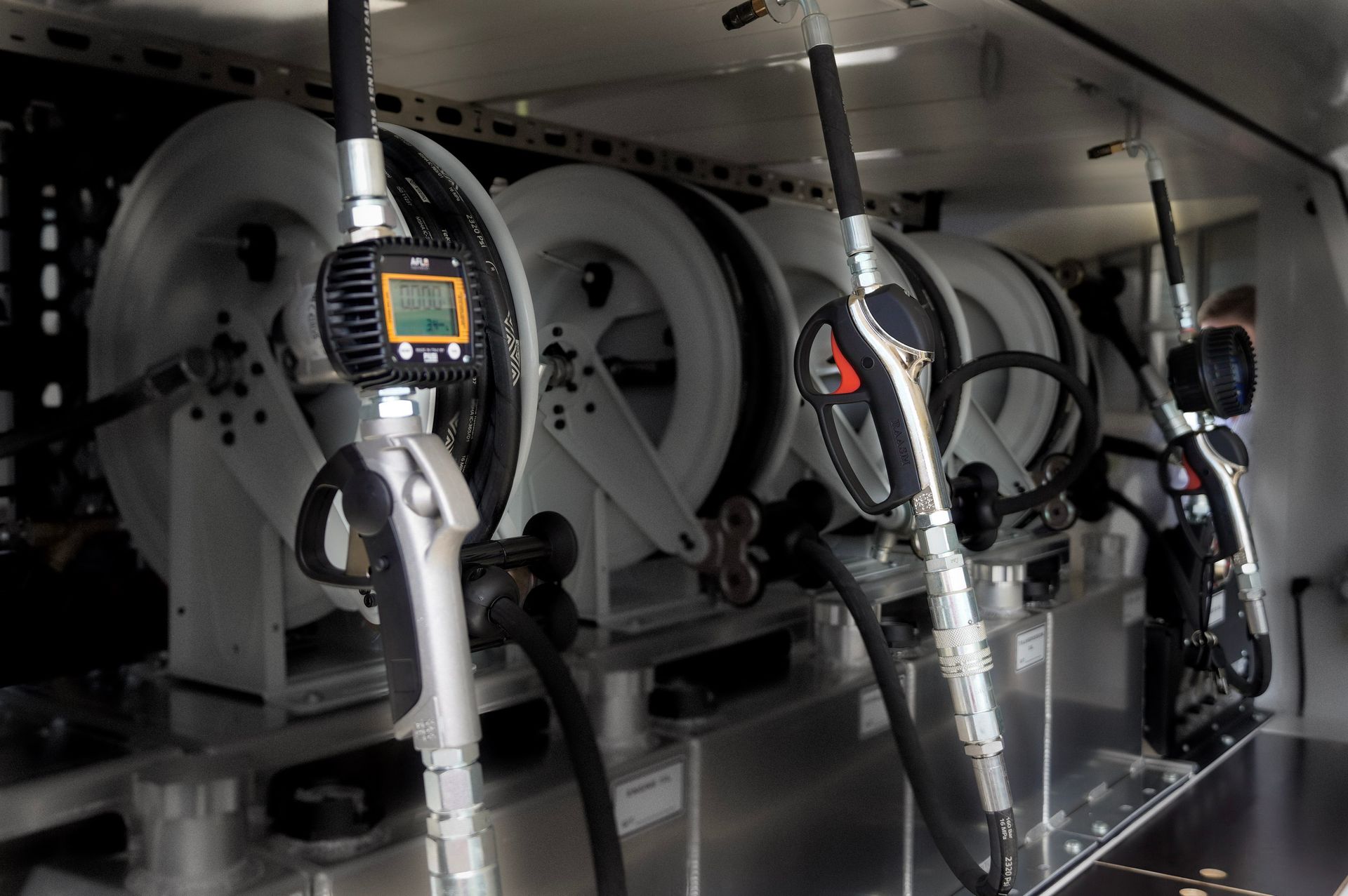 three different oil control guns installed on ox trailers service trailer reels and pumps for oil, fuel and lubricant.