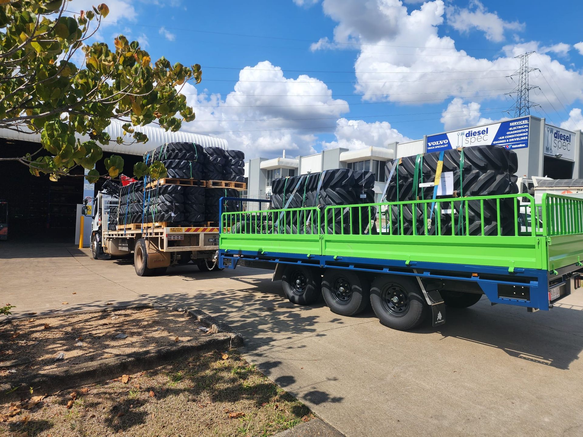 TKV tri-axle Flat Top Trailer with TKV tracks strapped onto the back for transport to rural QLD farms.