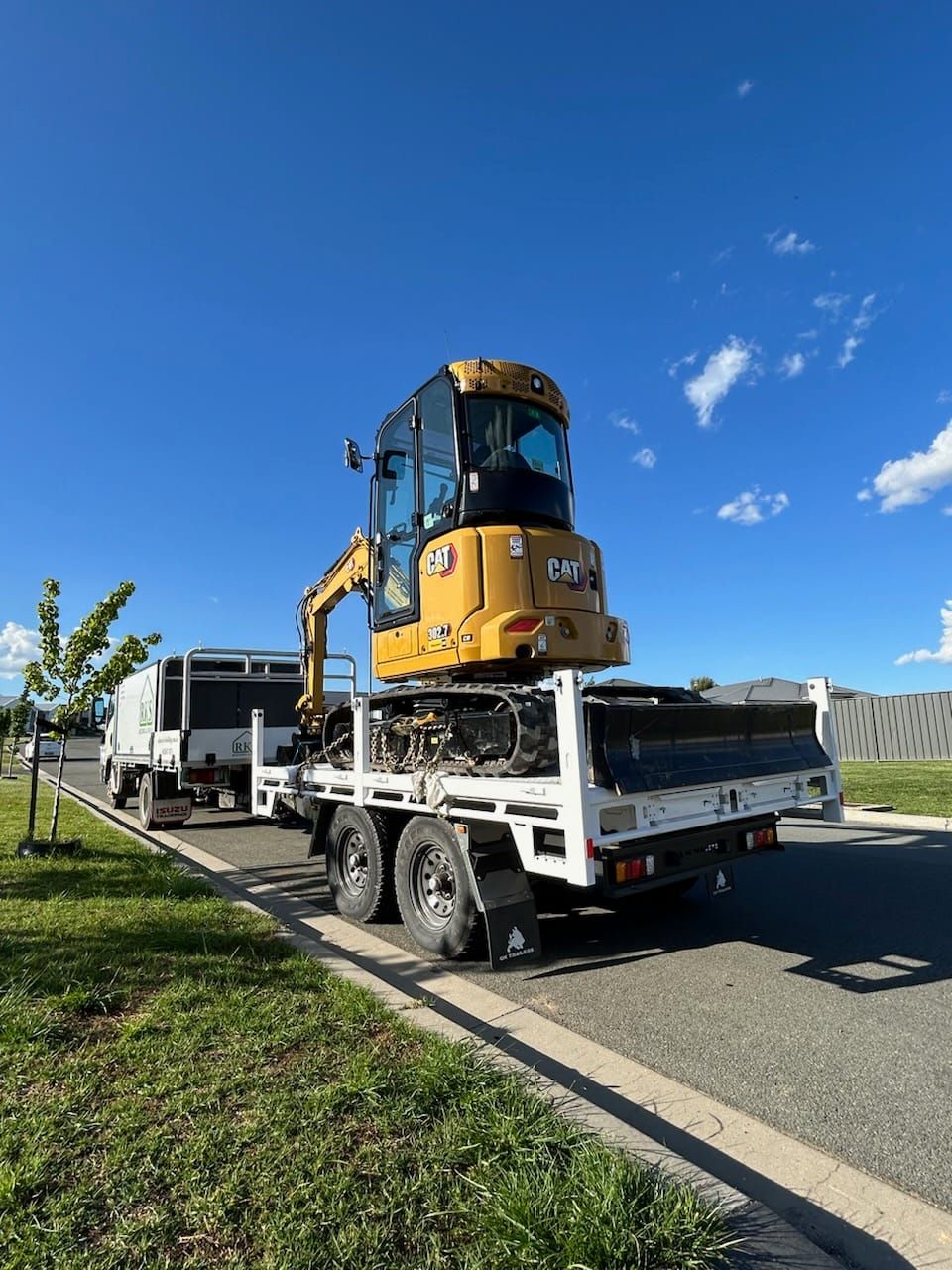 RKS Flat Top Trailer with excavator being towed by a isuzu truck.