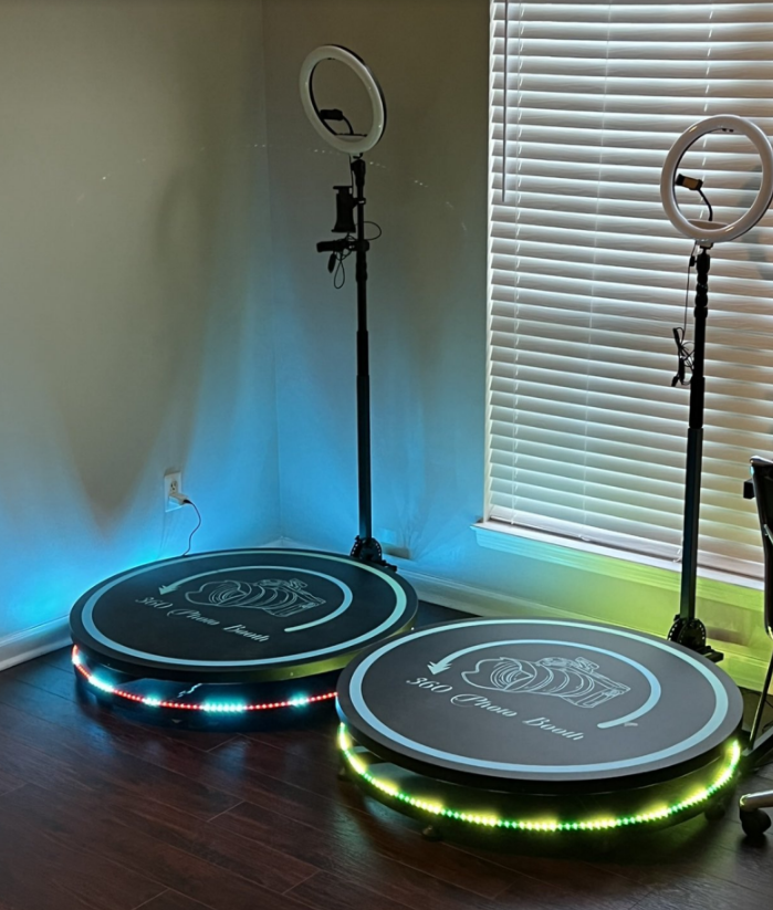 Two LED-lit round platforms with ring lights in a corner by a window blind.