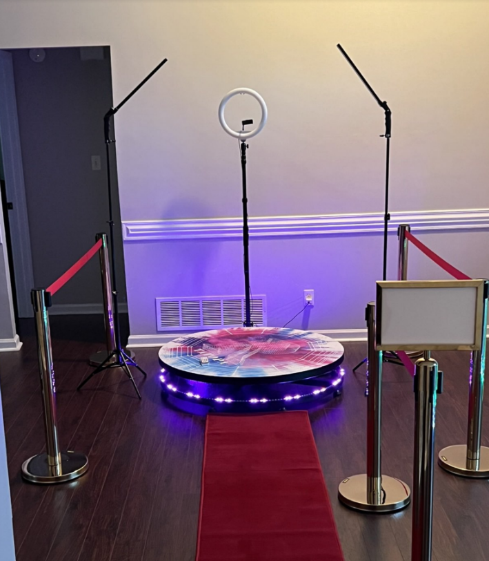 Red carpet leading to a ring light and photo booth setup with stanchions and purple accent lighting.