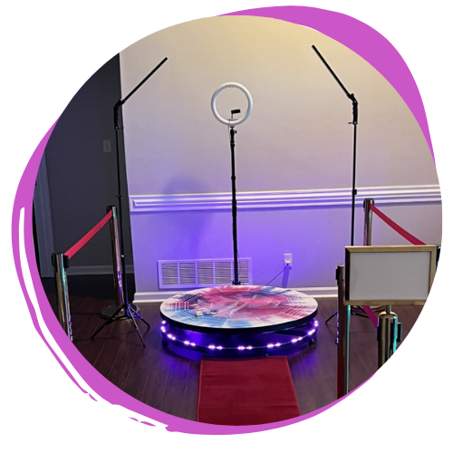 Small stage setup with ring light, microphone stand, black stands, red ropes, and a circular platform with LED lights.