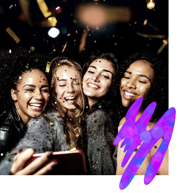 Four friends smiling and taking a selfie amid falling confetti at a celebration