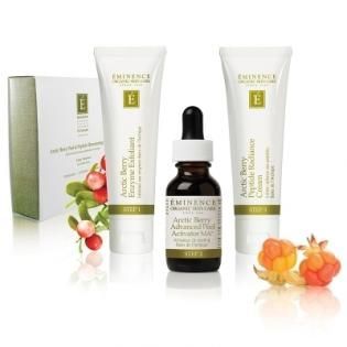 Eminence skin care products with white tubes, a dropper bottle, and peaches on a white background