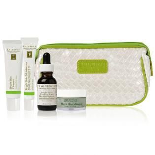 Skincare gift set with lotion tubes, dropper bottle, cream jar, and white zip pouch with green trim