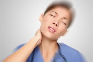 Person in blue scrubs holding their neck with eyes closed, showing pain or discomfort