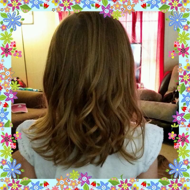 Back view of shoulder-length wavy brown hair in a room with floral border framing the image