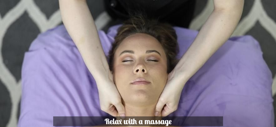 Woman receiving a facial massage with eyes closed, wearing a purple robe