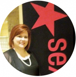 Woman standing beside a black sign with a red star and red vertical lettering
