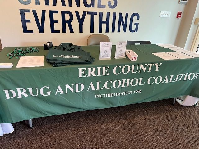 Erie County Drug and Alcohol Coalition table with green cloth and brochures at a health fair booth