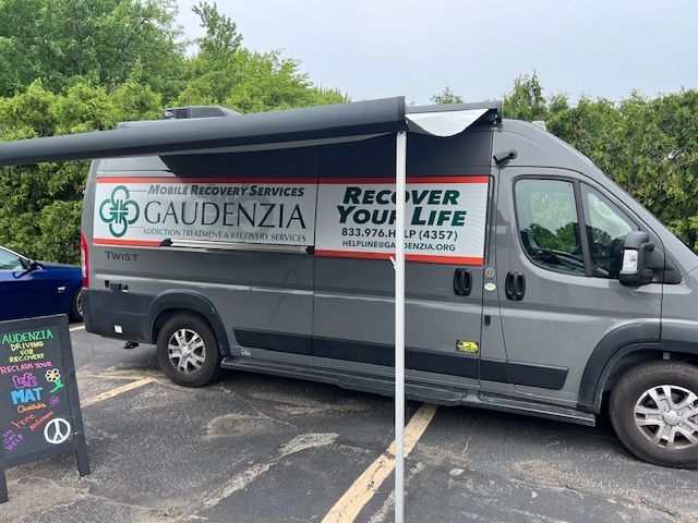 Gray van with Gaudenzia and “Recover Your Life” branding parked outdoors