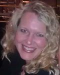 Smiling woman with curly blonde hair against a dark background