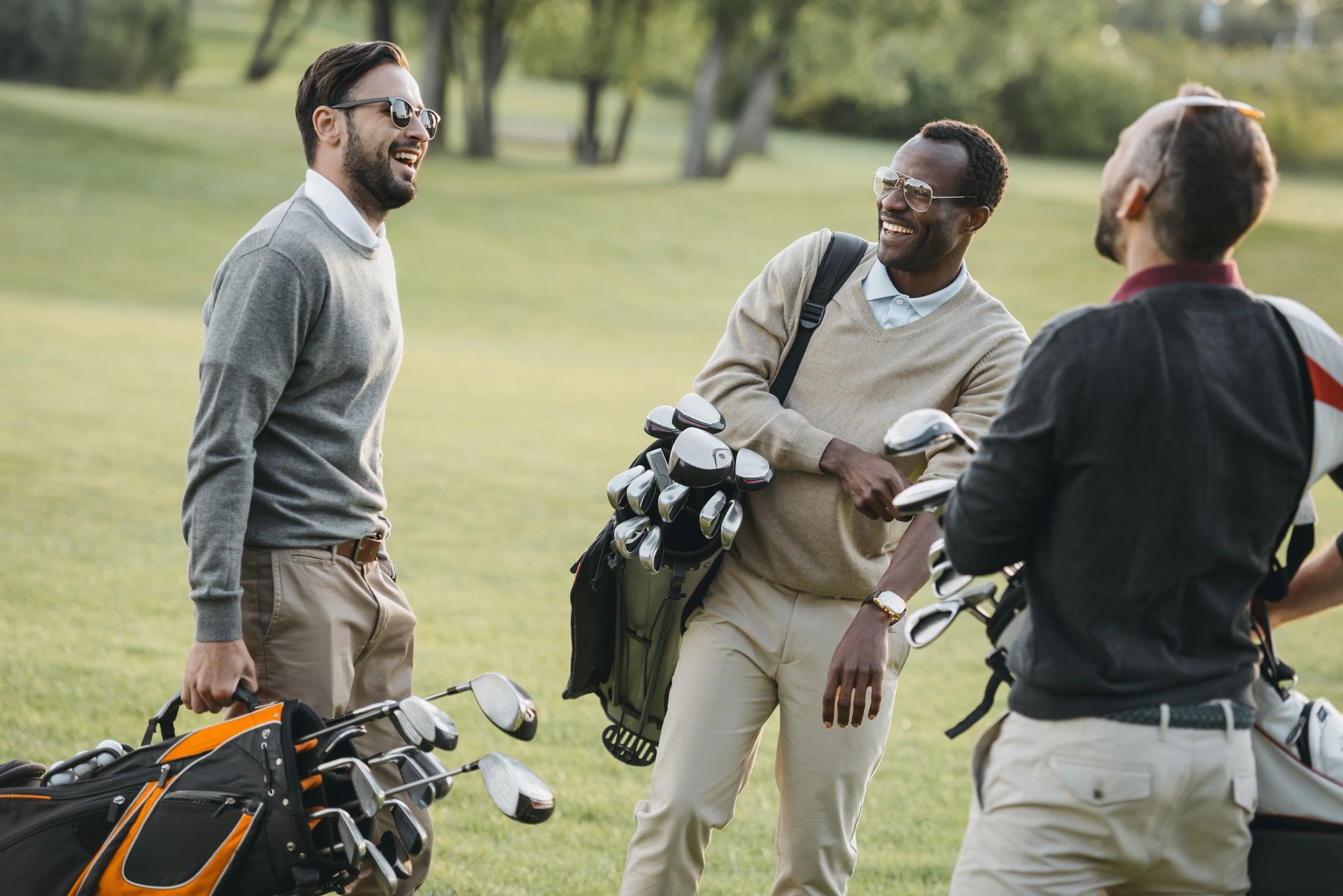three men on golf course smiling