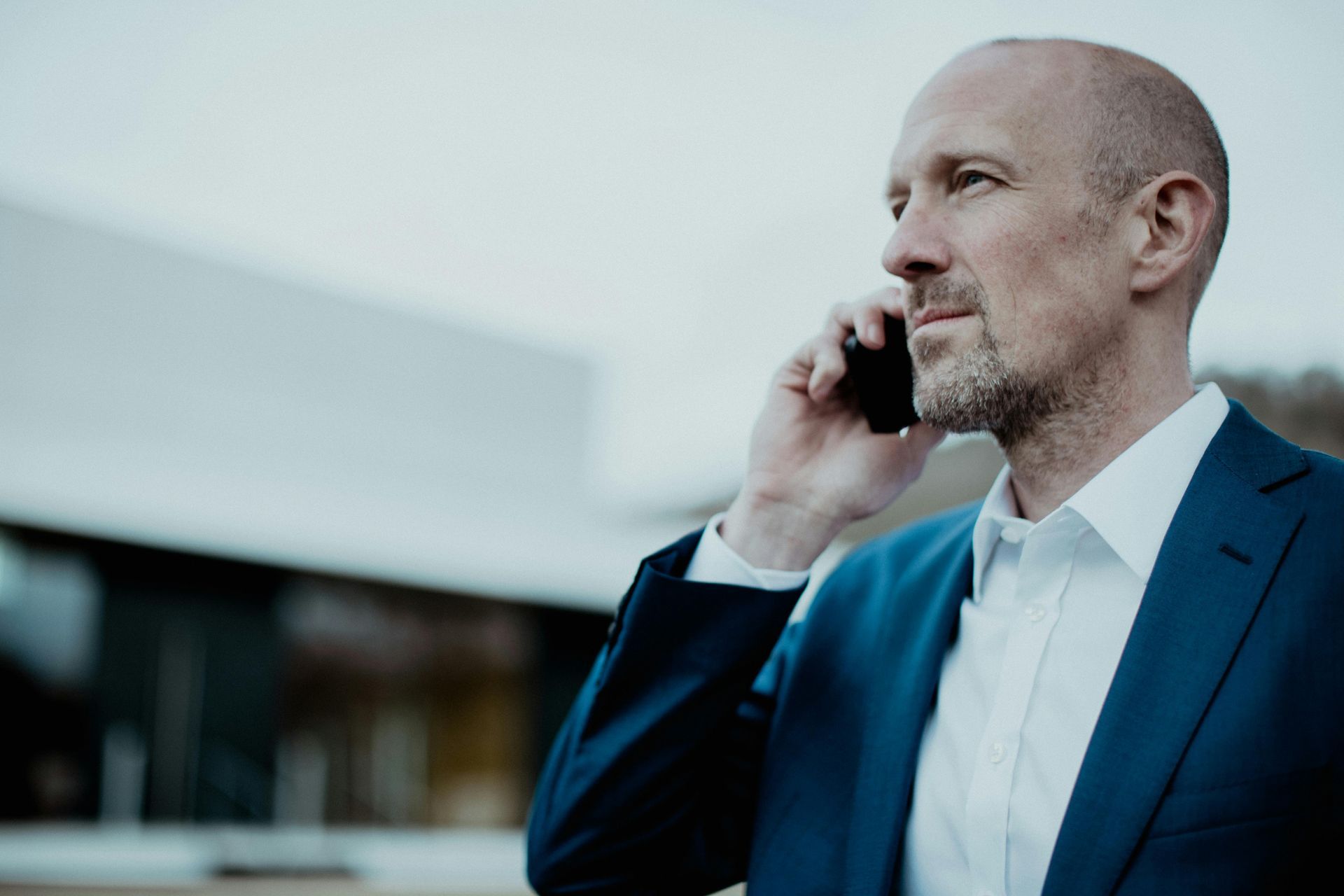 Man in suit on cell phone outdoors.