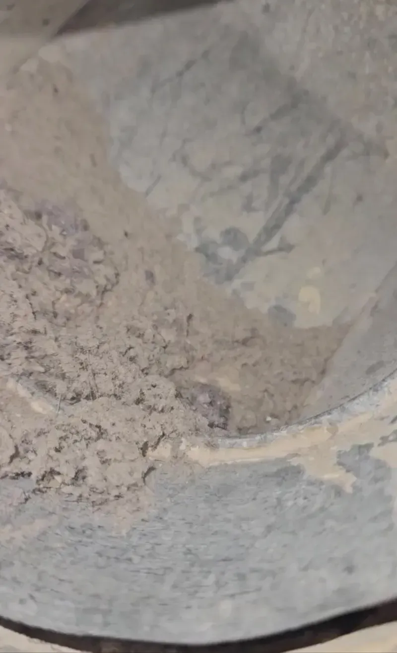 Close-up of a dusty gray metal surface with faint markings and a worn edge