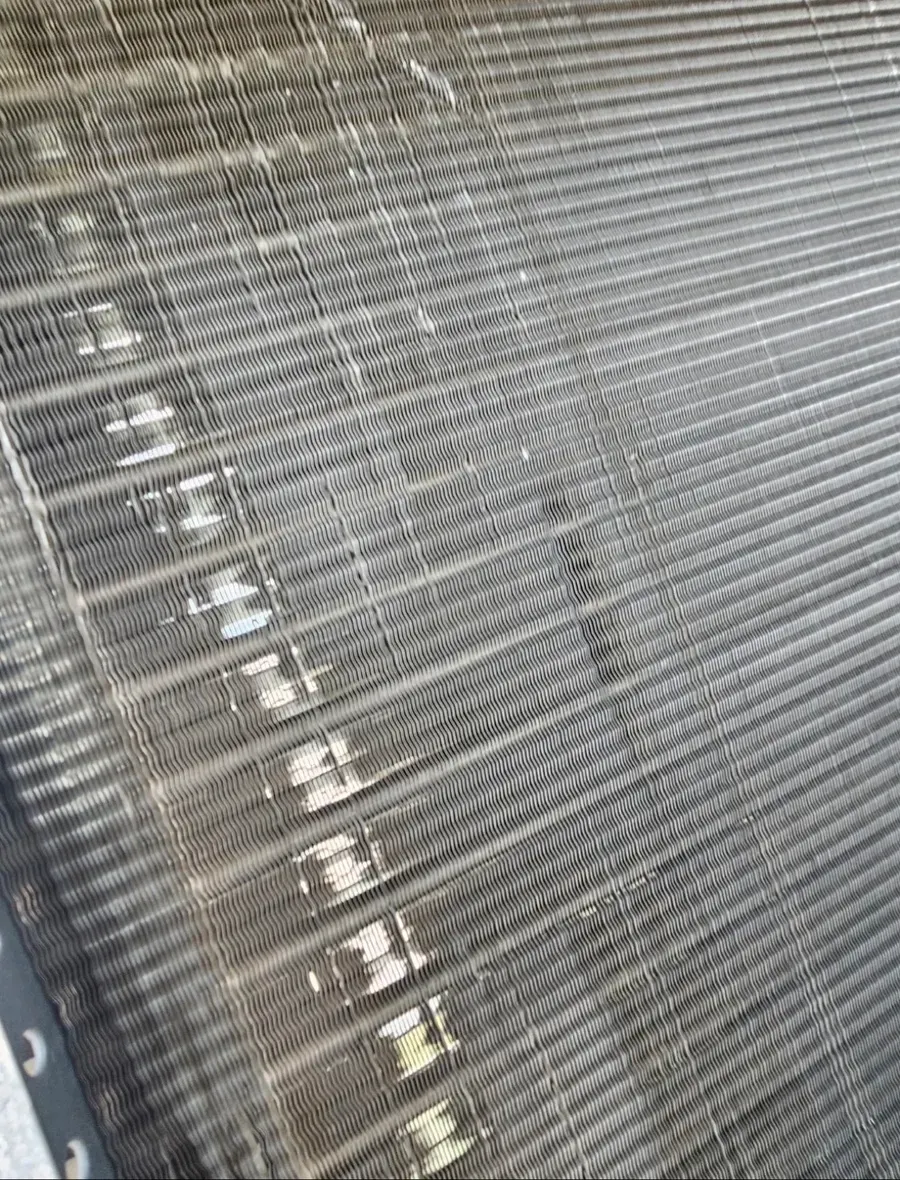 Close-up of a damaged woven or mesh surface with frayed threads and a striped pattern