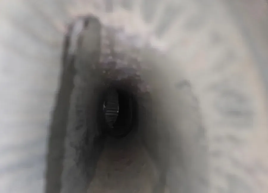 Close-up of a gray fabric tunnel with a dark circular opening in the center