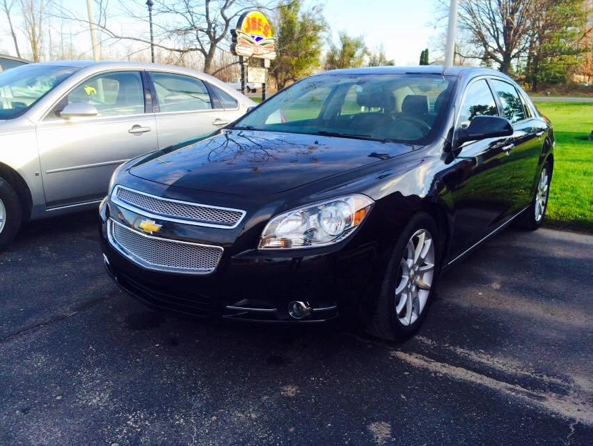 Black Chevrolet Malibu parked outside a building.