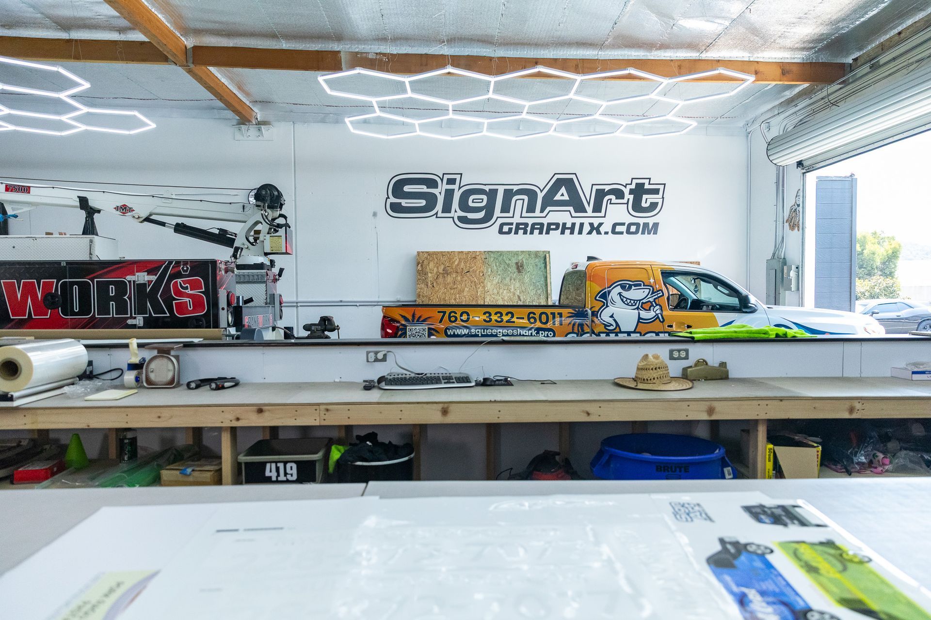 Inside a sign shop with a truck and equipment;