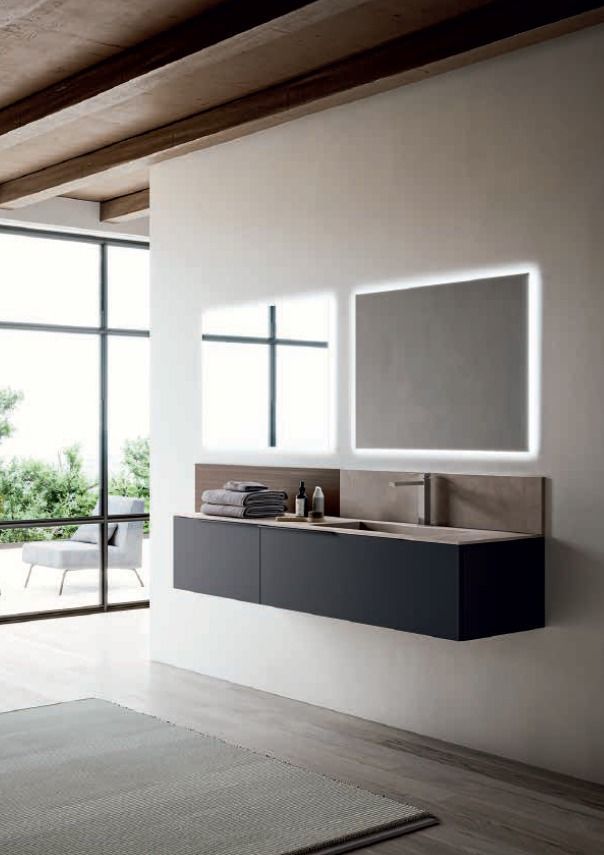 Mobile da bagno moderno con mobili sospesi scuri e specchio retroilluminato in un ambiente minimalista