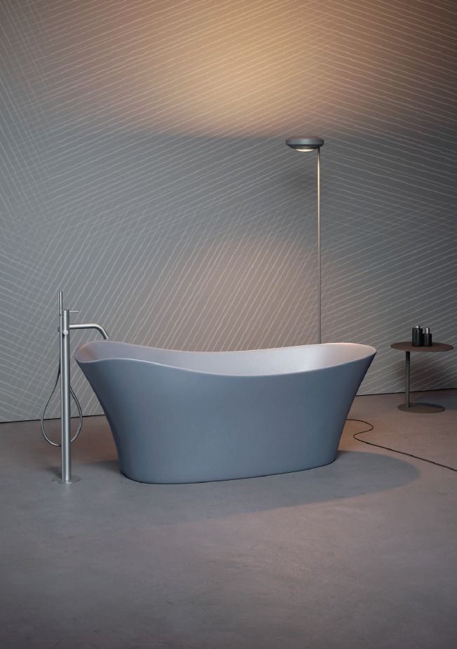 Moderna vasca da bagno freestanding con rubinetto a pavimento in un bagno minimalista