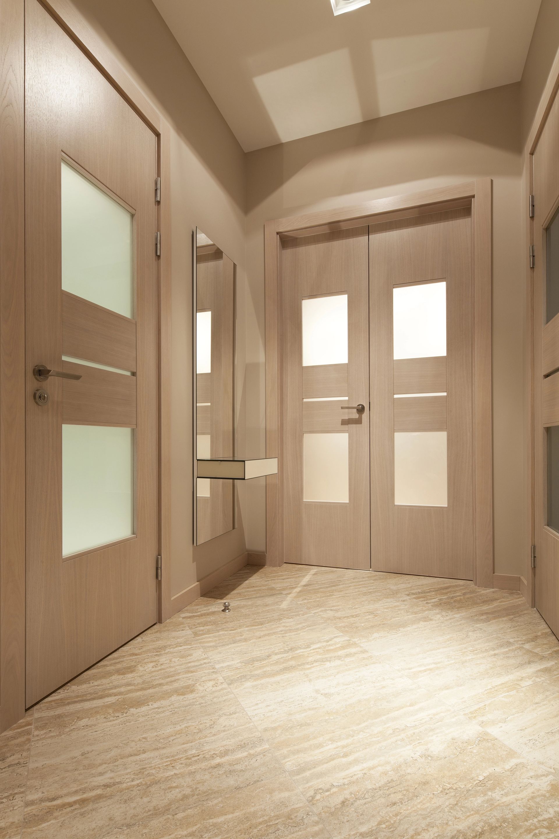 Ingresso moderno beige con doppie porte, pannelli in vetro satinato e finiture in legno caldo