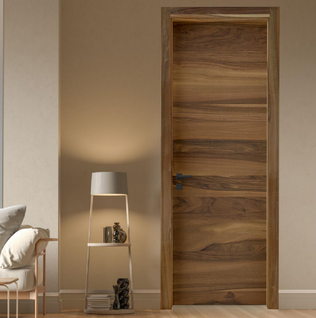 Camera moderna con una porta in legno, pareti beige e una piccola lampada su un tavolino.
