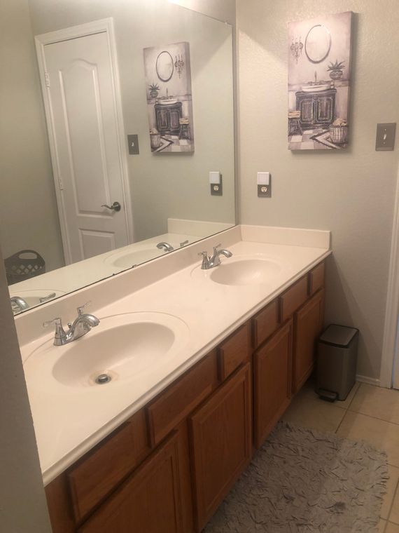 A bathroom with two sinks and a large mirror.