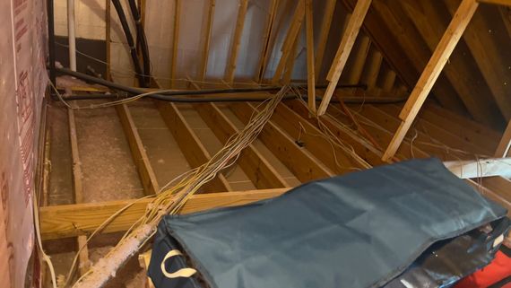 A bag is sitting in the attic of a house.