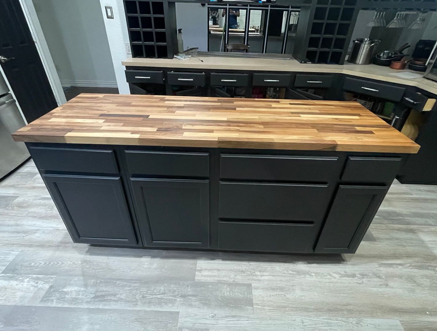 A kitchen with black cabinets and a wooden counter top.