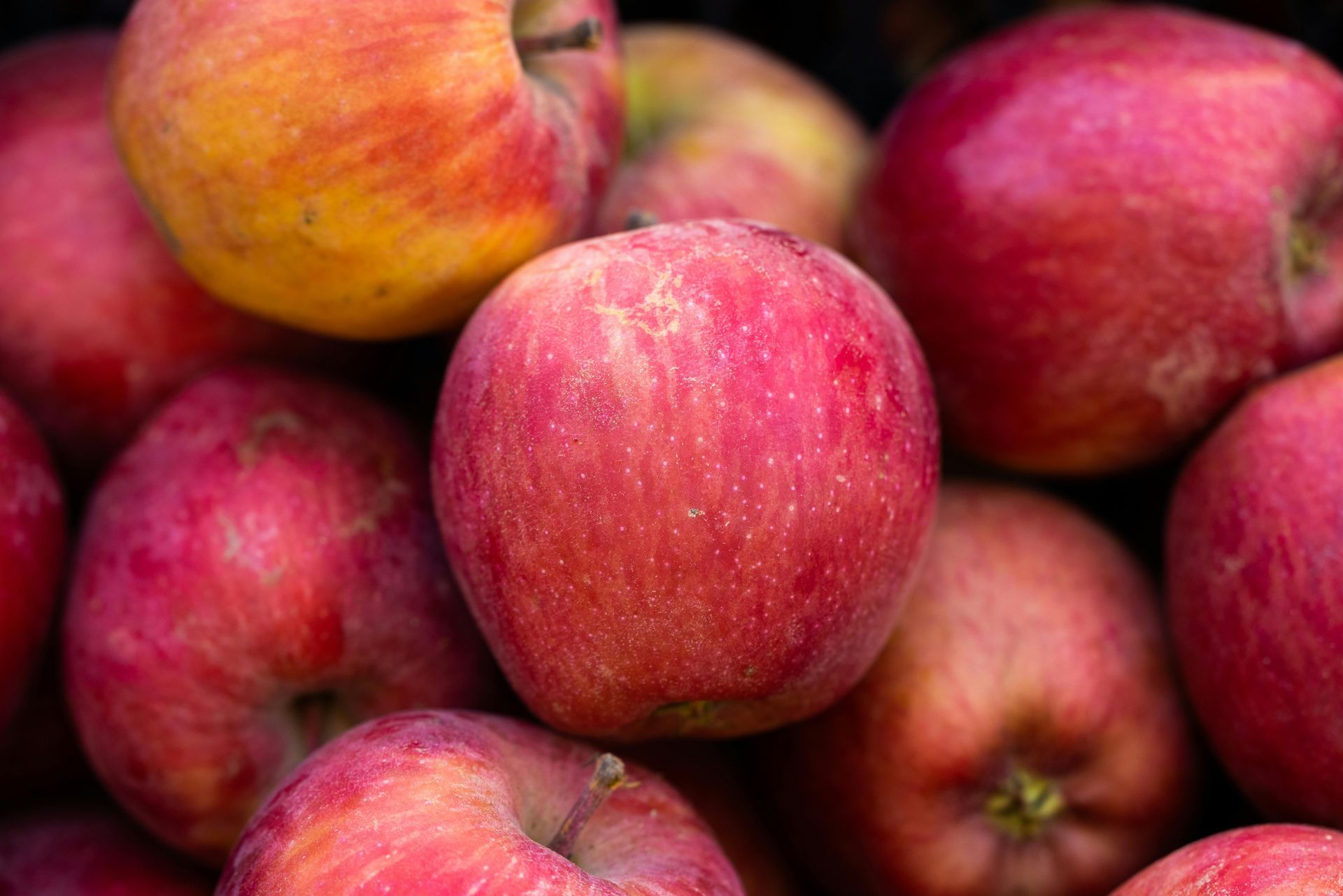 A bunch of red apples are stacked on top of each other.