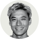 Black-and-white portrait of a smiling person with short hair on a plain light background