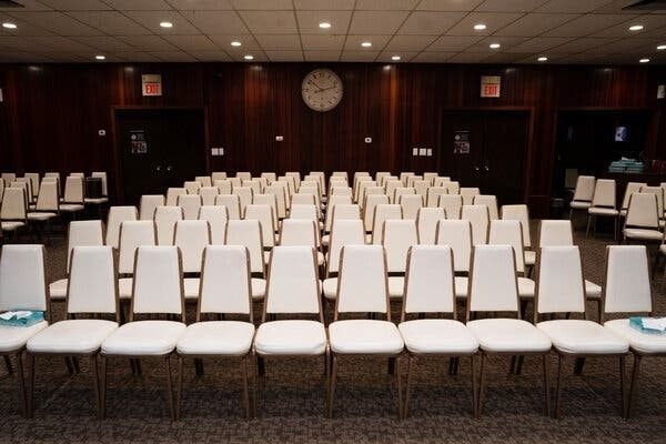Empty conference room with rows of white chairs facing the front