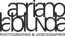 Logo in bianco e nero con la scritta “adriano lablunda photographer & videographer”