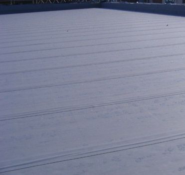 A close up of a roof with a tree in the background.