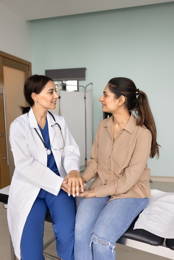 Healthcare provider offering compassionate pregnancy support to a young woman at a clinic.