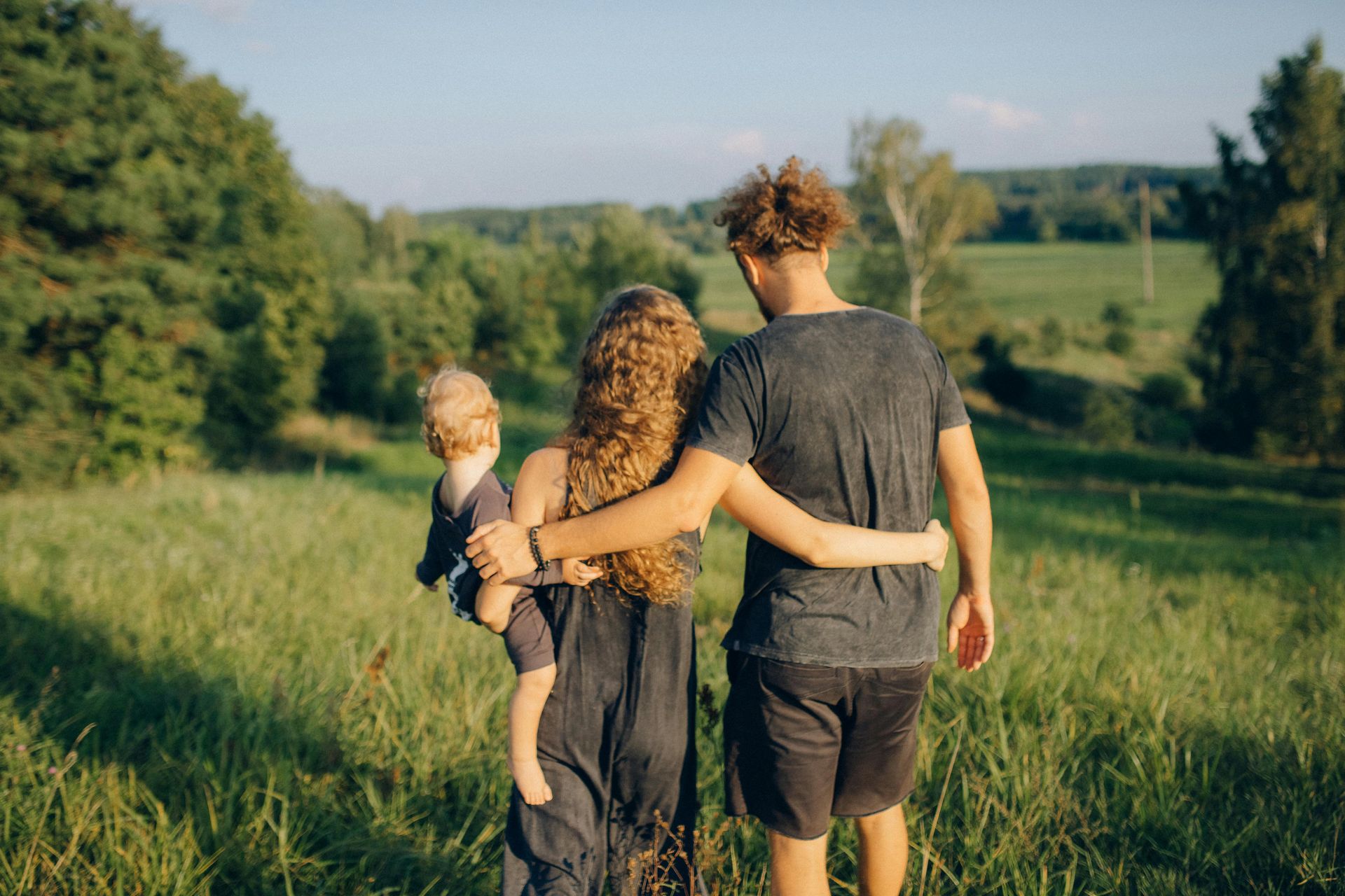 Young family walking together outdoors, symbolizing support, connection, and hopeful future