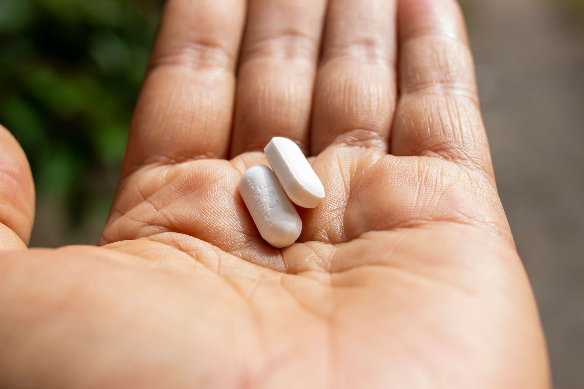 Two white pills resting in an open palm