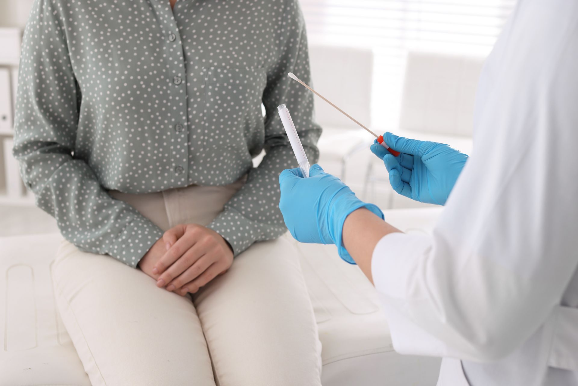 Healthcare provider preparing STI swab test with patient during private, confidential clinic visit